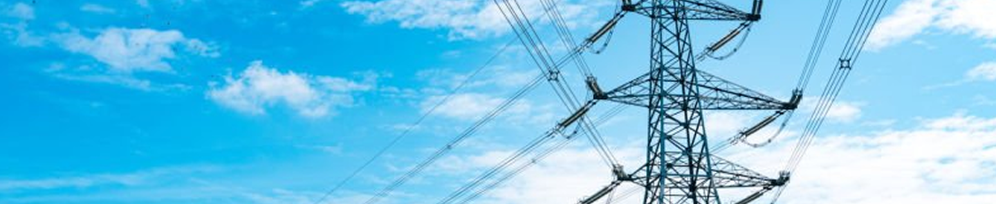 Overhead power transmission tower with multiple high-voltage lines set against a blue sky with scattered clouds.